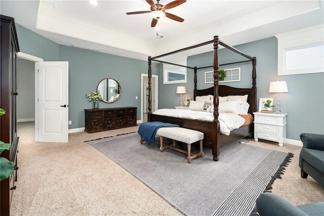 carpeted bedroom with baseboards, ceiling fan, and a tray ceiling