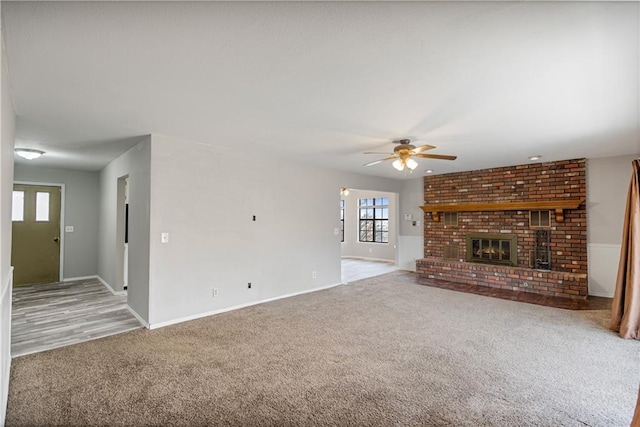 unfurnished living room with ceiling fan, light colored carpet, and a fireplace