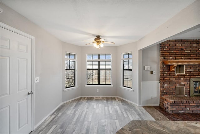 interior space with hardwood / wood-style floors, a wood stove, and ceiling fan