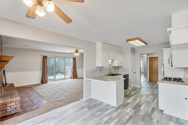 kitchen featuring sink, white cabinetry, kitchen peninsula, and light hardwood / wood-style floors