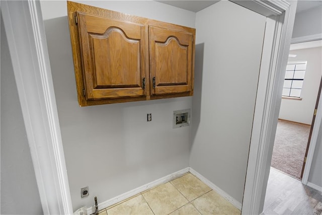 clothes washing area featuring washer hookup, cabinets, light tile patterned floors, and hookup for an electric dryer