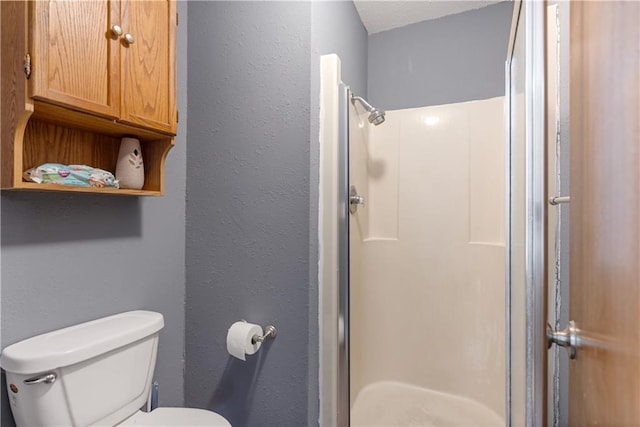 bathroom with toilet and walk in shower