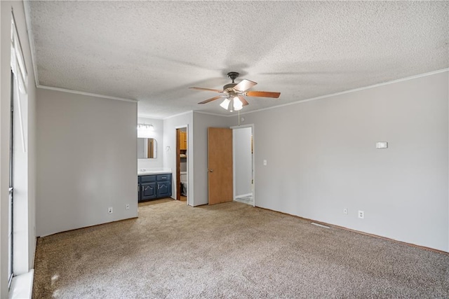 unfurnished bedroom with crown molding, light carpet, a textured ceiling, and ensuite bathroom