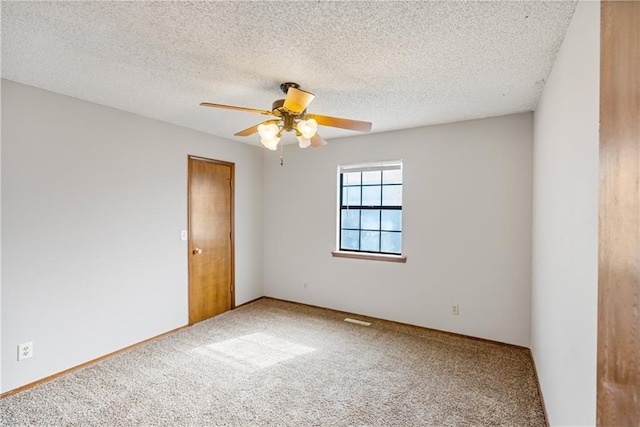 carpeted empty room featuring ceiling fan and a textured ceiling