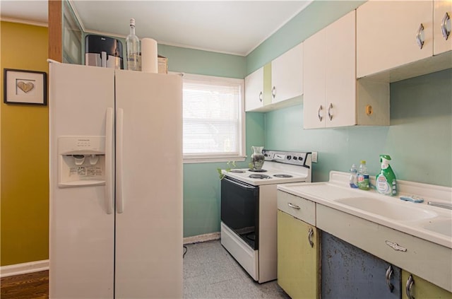 kitchen featuring sink, white appliances, and white cabinetry