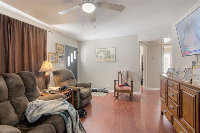 living room featuring ceiling fan, dark wood-type flooring, and baseboards