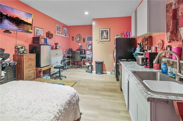 bedroom featuring light hardwood / wood-style flooring and sink