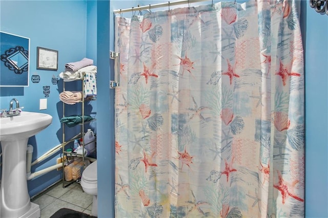 bathroom with a shower with curtain, tile patterned floors, toilet, and sink