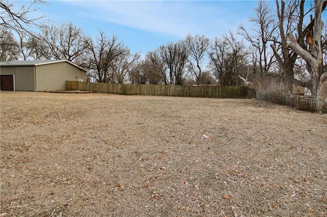 view of yard featuring an outdoor structure and fence