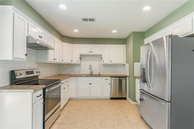 11413 Palmer Ave, Kansas City, MO 64134 - kitchen featuring stainless steel appliances, under cabinet range hood, white cabinets, tasteful backsplash, and light countertops