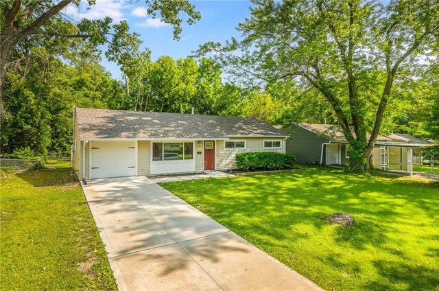 11413 Palmer Ave, Kansas City, MO 64134 - view of front of home featuring concrete driveway, an attached garage, and a front lawn