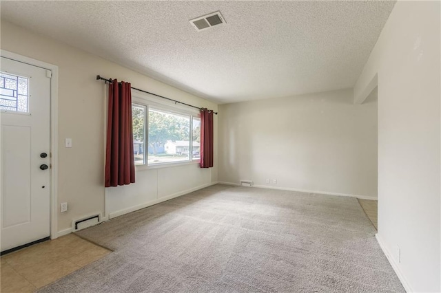 11413 Palmer Ave, Kansas City, MO 64134 - entrance foyer featuring a textured ceiling, carpet floors, and a baseboard radiator