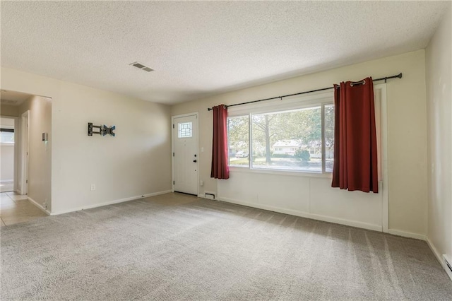 11413 Palmer Ave, Kansas City, MO 64134 - carpeted foyer featuring a textured ceiling and baseboard heating