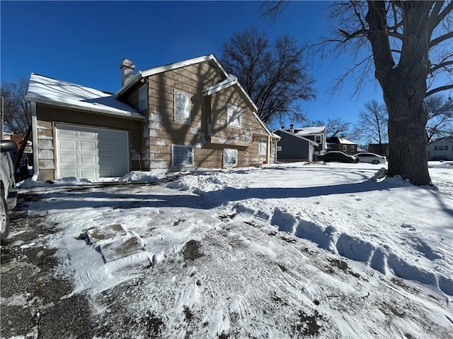 exterior space featuring a chimney and an attached garage