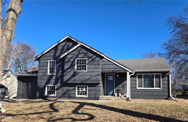 split level home featuring an attached garage and a front yard