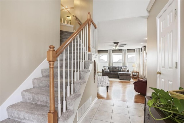 staircase with ceiling fan, baseboards, visible vents, and tile patterned floors