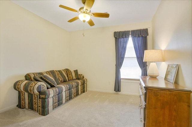 living room featuring baseboards, a ceiling fan, and light colored carpet