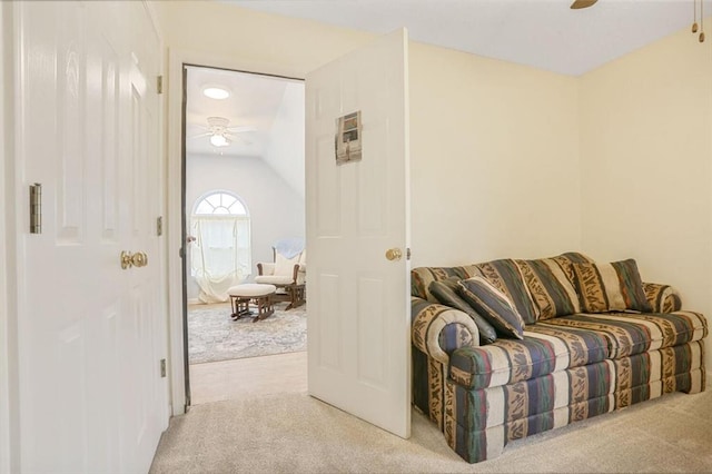 interior space with light carpet, ceiling fan, and vaulted ceiling