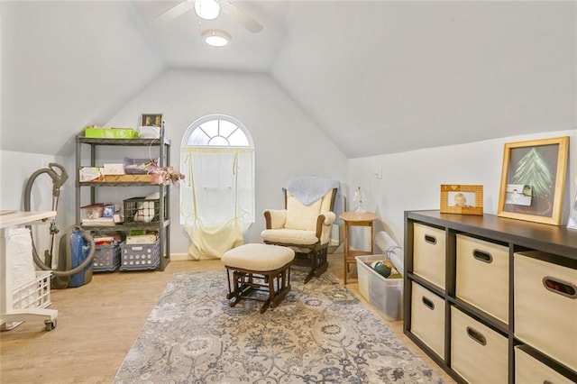 living area featuring lofted ceiling, a ceiling fan, and wood finished floors