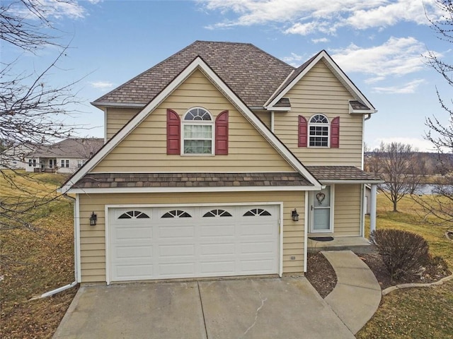 traditional-style home with a garage, concrete driveway, and roof with shingles