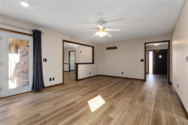 unfurnished room featuring visible vents, baseboards, ceiling fan, a textured ceiling, and light wood-style floors