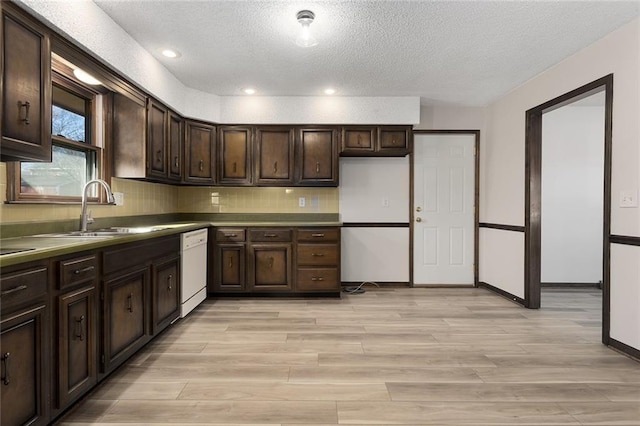 kitchen with white dishwasher, light wood-style flooring, a sink, and dark brown cabinets