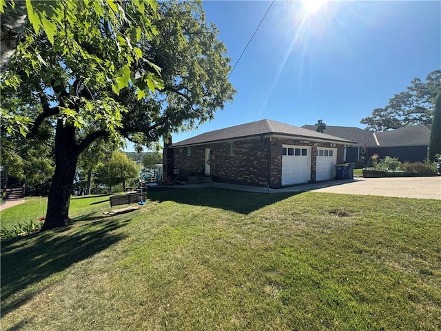 view of side of home with a garage, a yard, concrete driveway, and brick siding