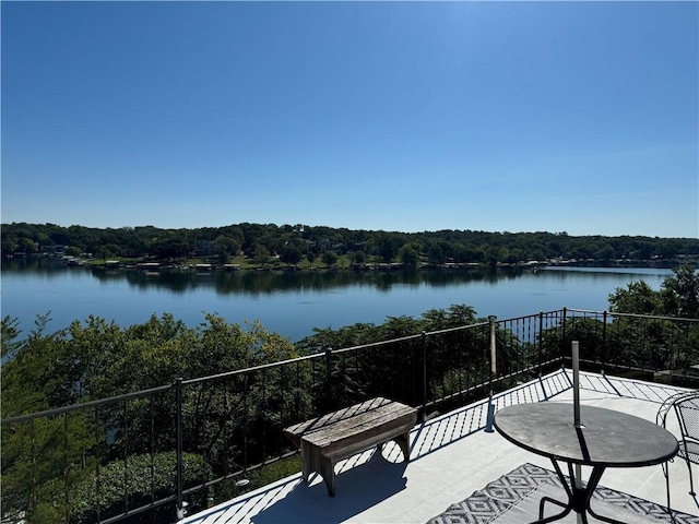 balcony with a water view and a view of trees