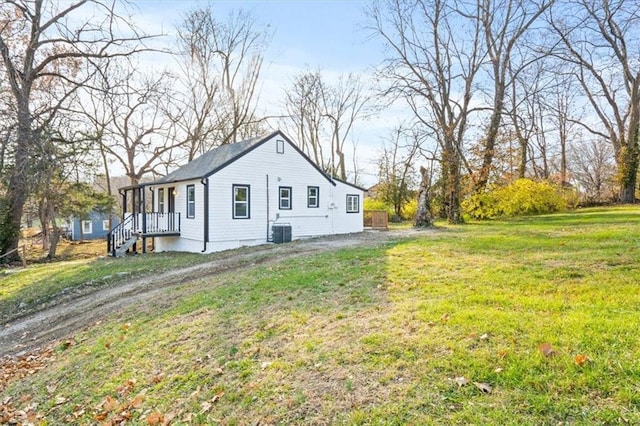 exterior space with central air condition unit and a yard