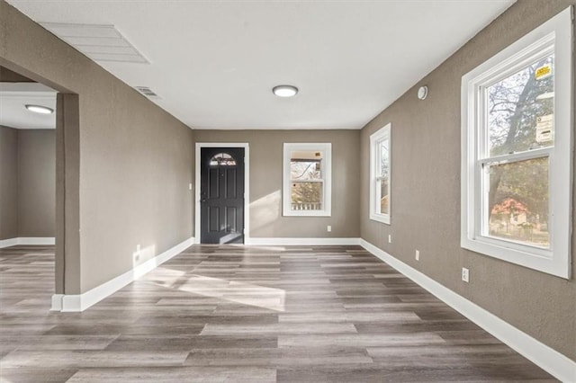 spare room featuring wood finished floors, visible vents, and baseboards