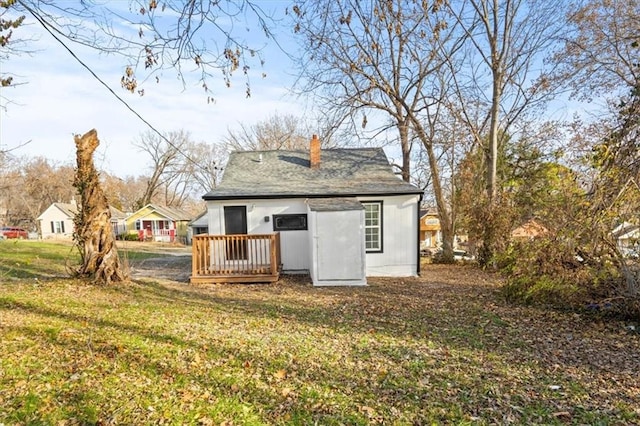 back of property with a lawn and a chimney