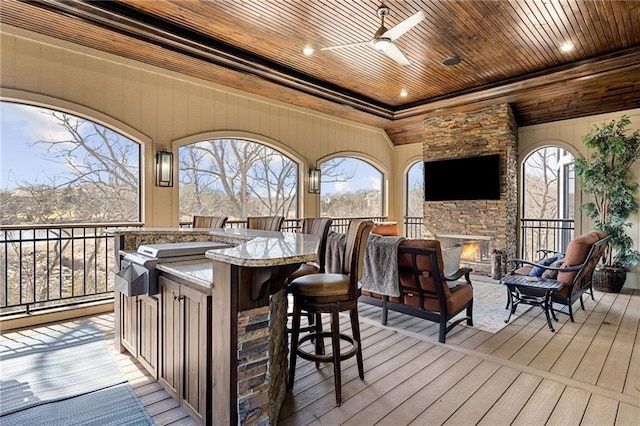 wooden terrace featuring outdoor dry bar and a ceiling fan