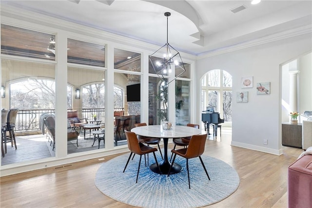 dining area with crown molding, wood finished floors, visible vents, and baseboards