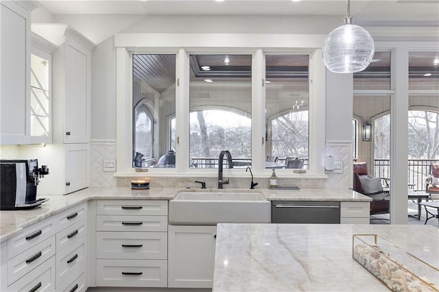 kitchen with hanging light fixtures, dishwasher, white cabinetry, and a sink