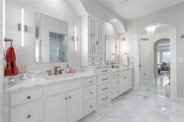 bathroom featuring wallpapered walls, double vanity, marble finish floor, and a sink