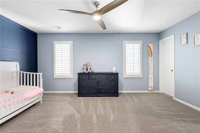 carpeted bedroom featuring multiple windows, visible vents, baseboards, and ceiling fan