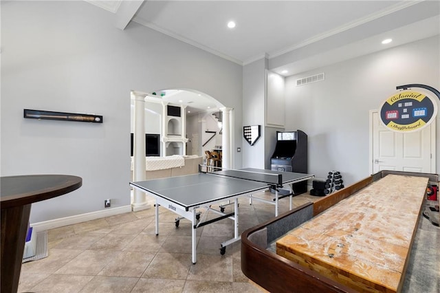 playroom featuring visible vents, baseboards, decorative columns, arched walkways, and ornamental molding