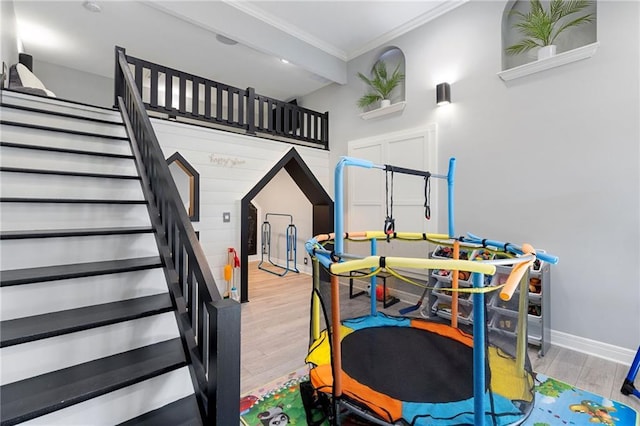 playroom with baseboards, wood finished floors, and crown molding