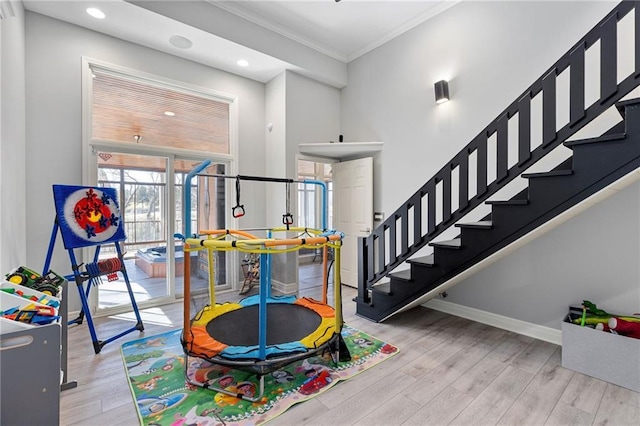 game room featuring recessed lighting, baseboards, wood finished floors, and crown molding