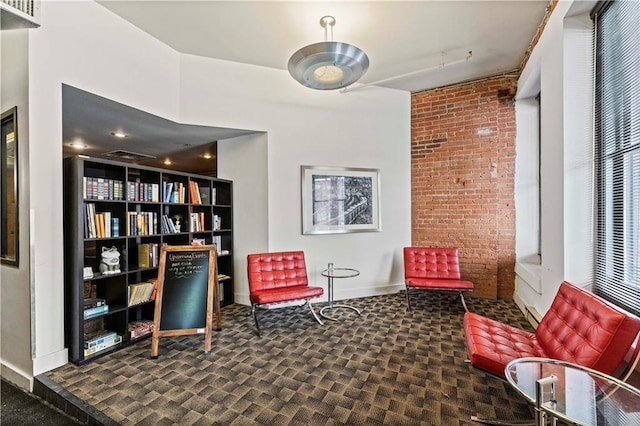 sitting room featuring brick wall