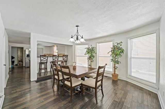 dining space with baseboards, a chandelier, dark wood finished floors, and a textured ceiling