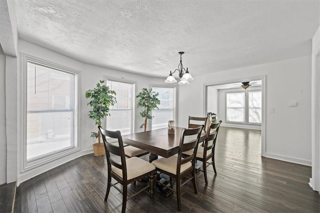 dining room featuring a notable chandelier, dark wood finished floors, a textured ceiling, and baseboards