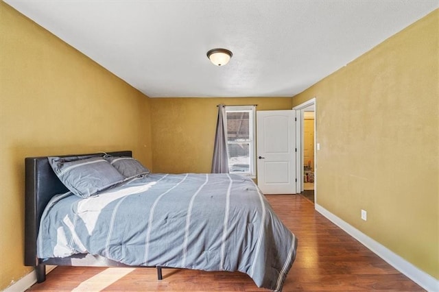 bedroom featuring baseboards and wood finished floors