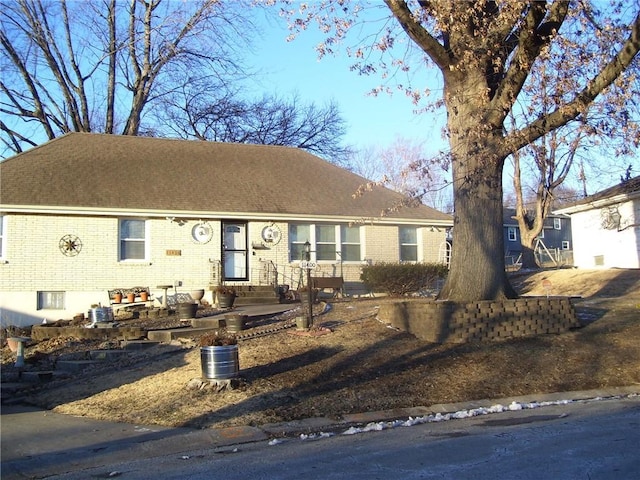 ranch-style home with brick siding and a shingled roof