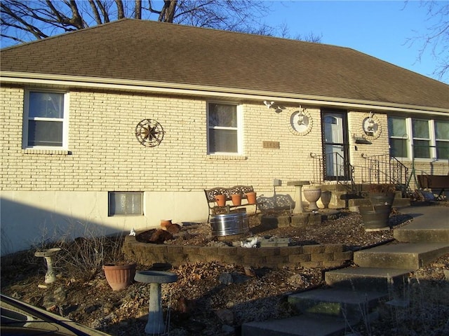 view of front of property with roof with shingles and brick siding