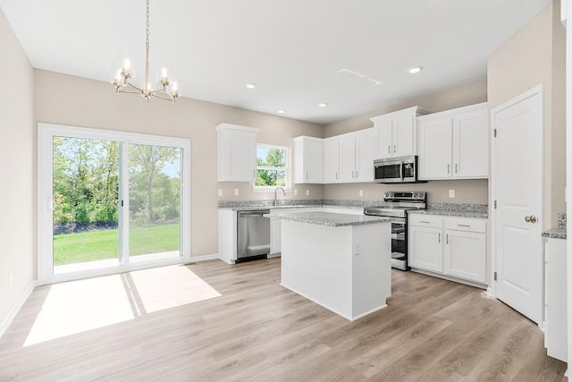 kitchen featuring stainless steel appliances, white cabinetry, and light stone countertops