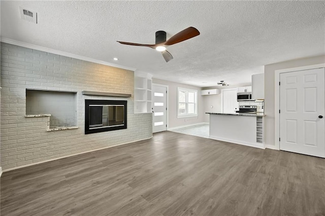 unfurnished living room with ceiling fan, dark hardwood / wood-style flooring, a wall mounted AC, and a textured ceiling