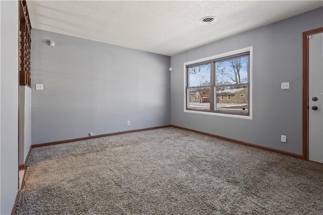 carpeted spare room with a textured ceiling, visible vents, and baseboards