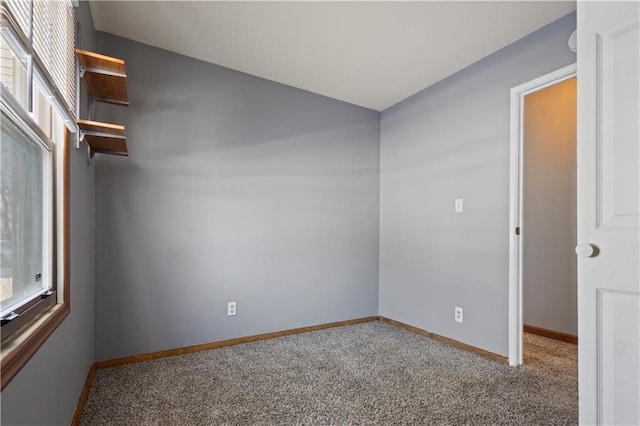 carpeted spare room with plenty of natural light and baseboards