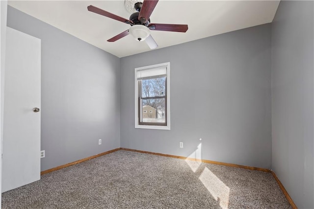 spare room with ceiling fan, carpet, and baseboards